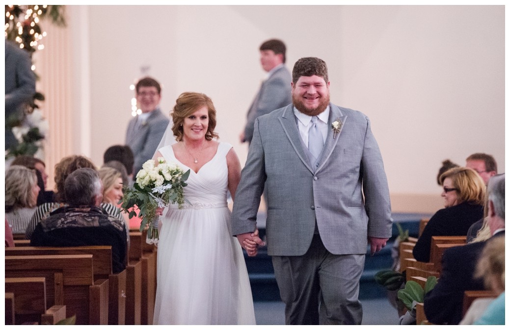 bride and groom coming down the aisle after wedding