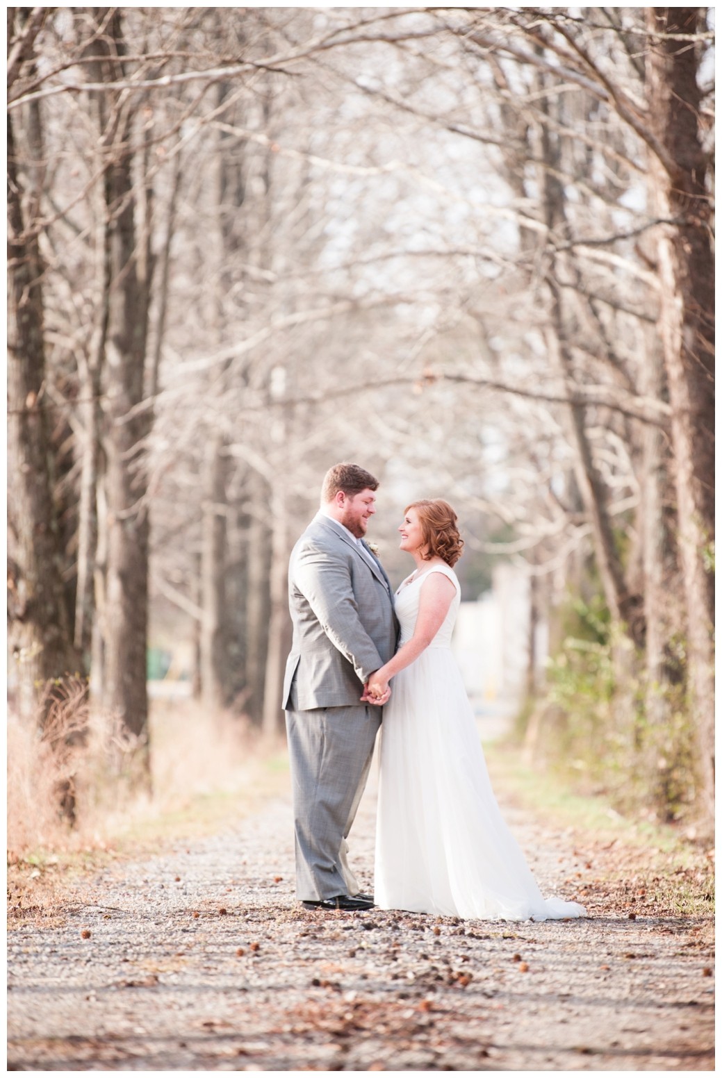 bride and groom on path looking at one another in winter