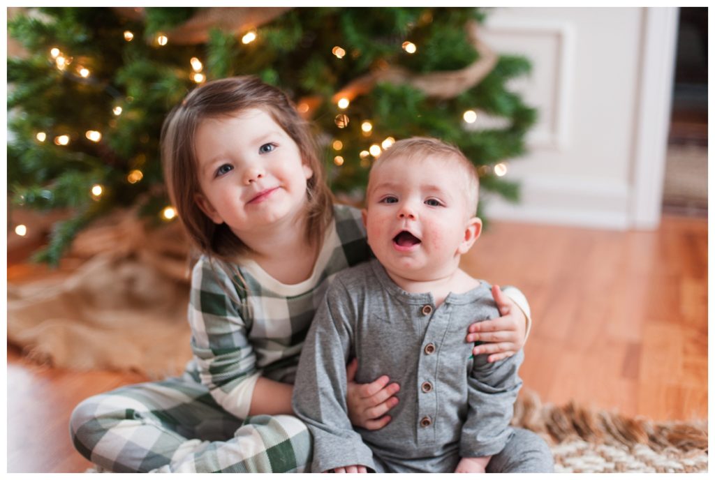 six month session little boy and sister by christmas tree