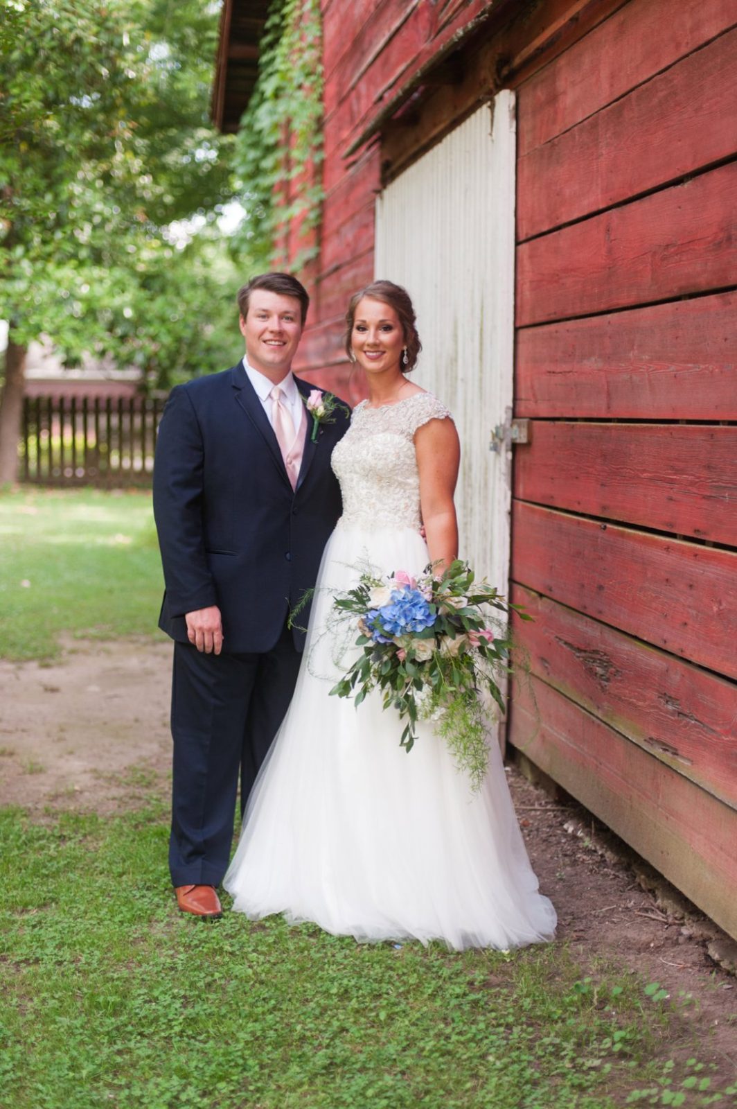 The Columns in Bolivar & Falcon Ridge Farm Wedding bride and groom in front of barn