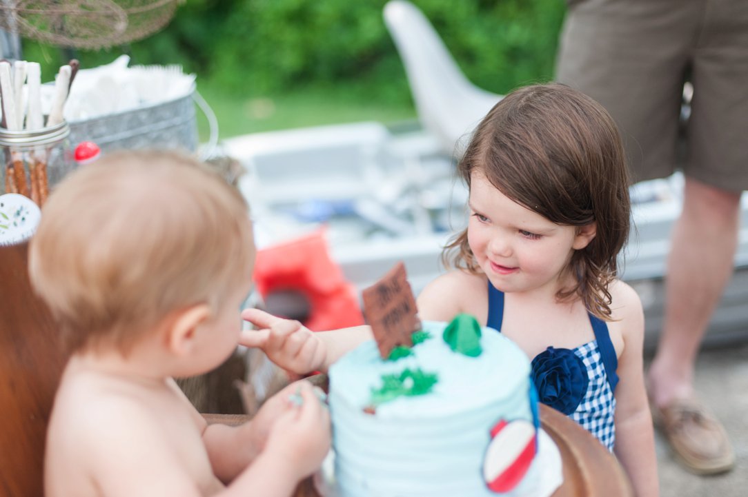 first birthday party sister feeding cake