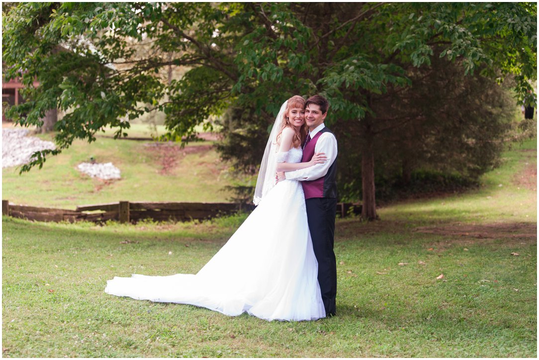 Summer lakeside Wedding bride and groom in front of tree