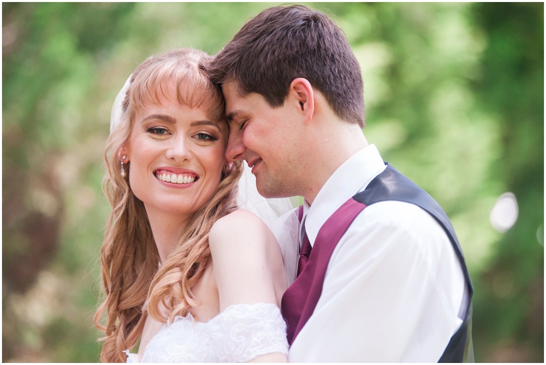 Summer lakeside Wedding bride looking at camera with groom