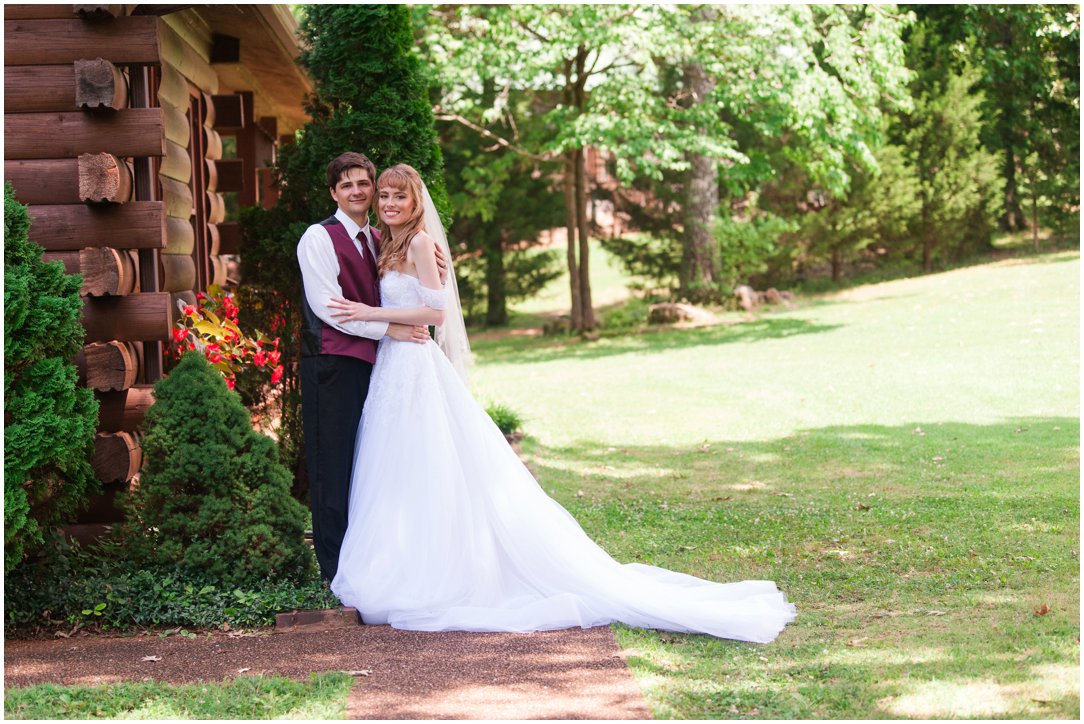 Summer lakeside Wedding couple standing by cabin