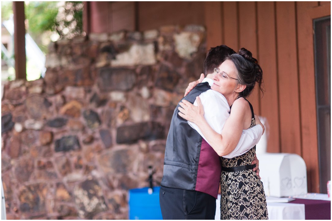 Summer lakeside Wedding groom hugging mom