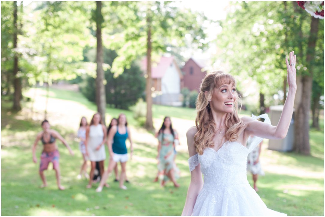 Summer lakeside Wedding bride throwing bouquet