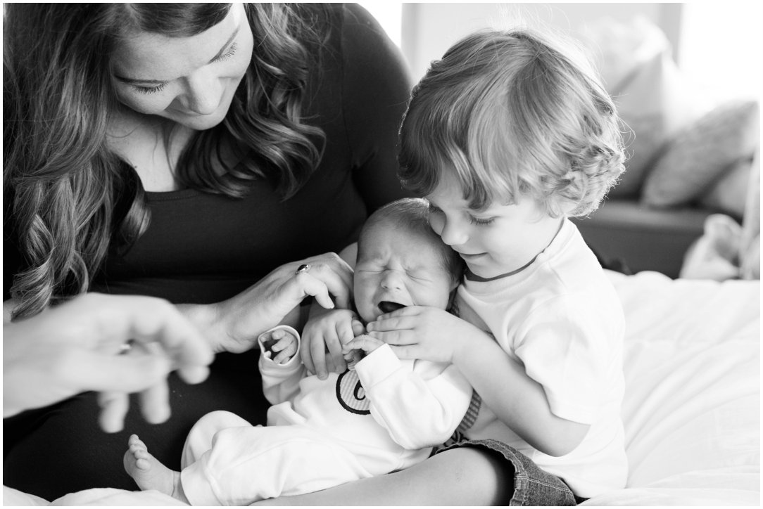 Big brother holding newborn brother