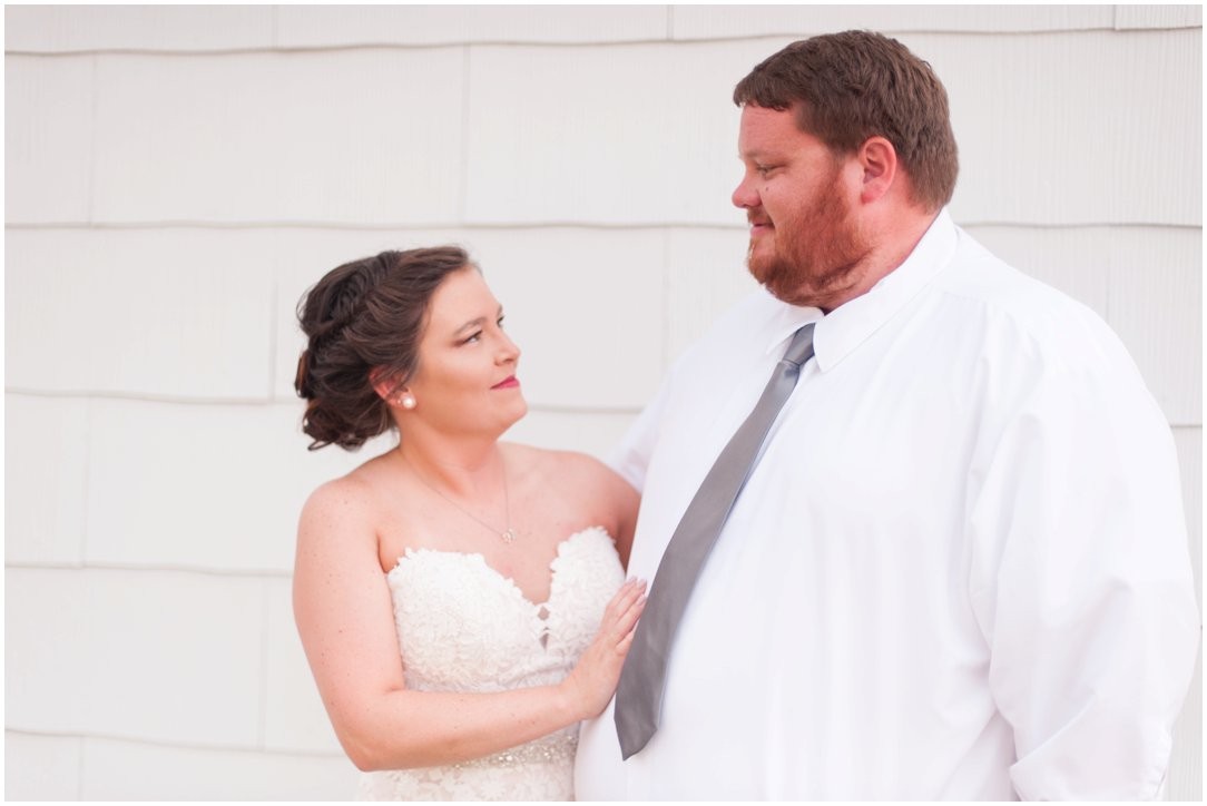 bride and groom in front of white wall