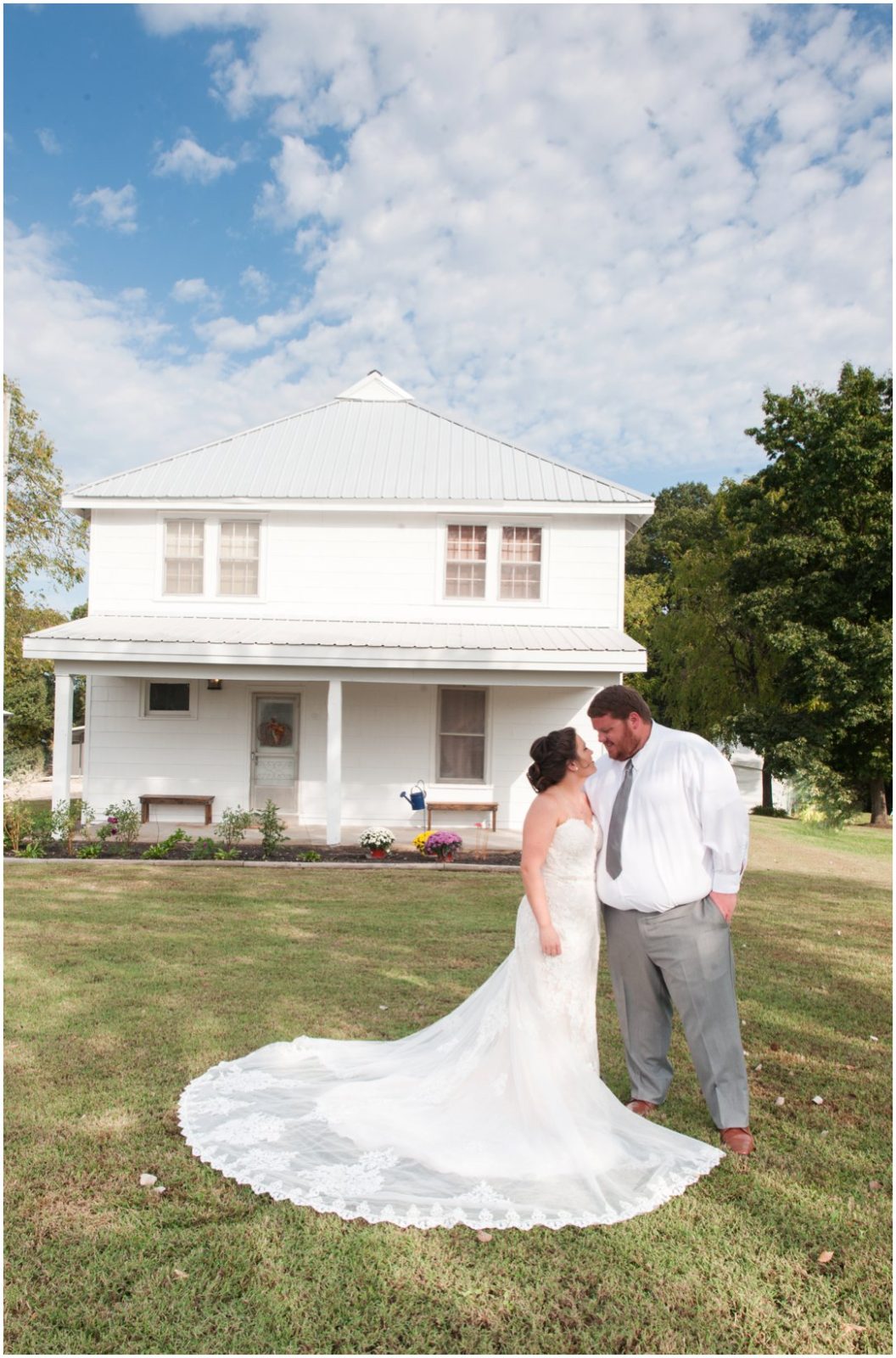 bride and groom in front of farmhouse fall farm wedding