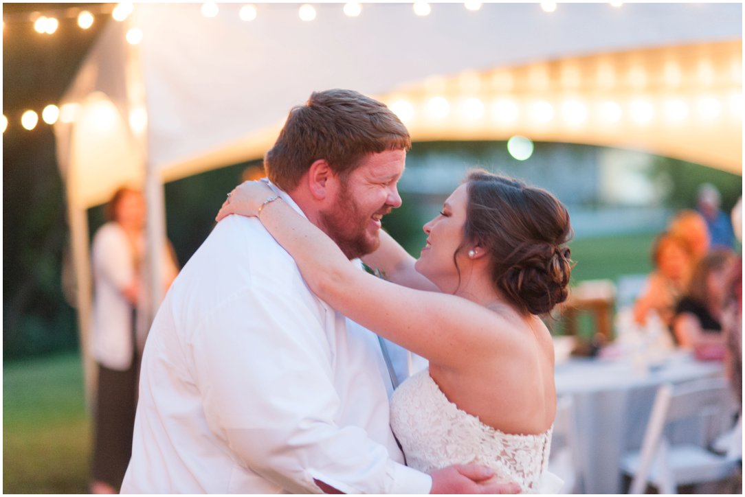 bride and groom first dance beside tent