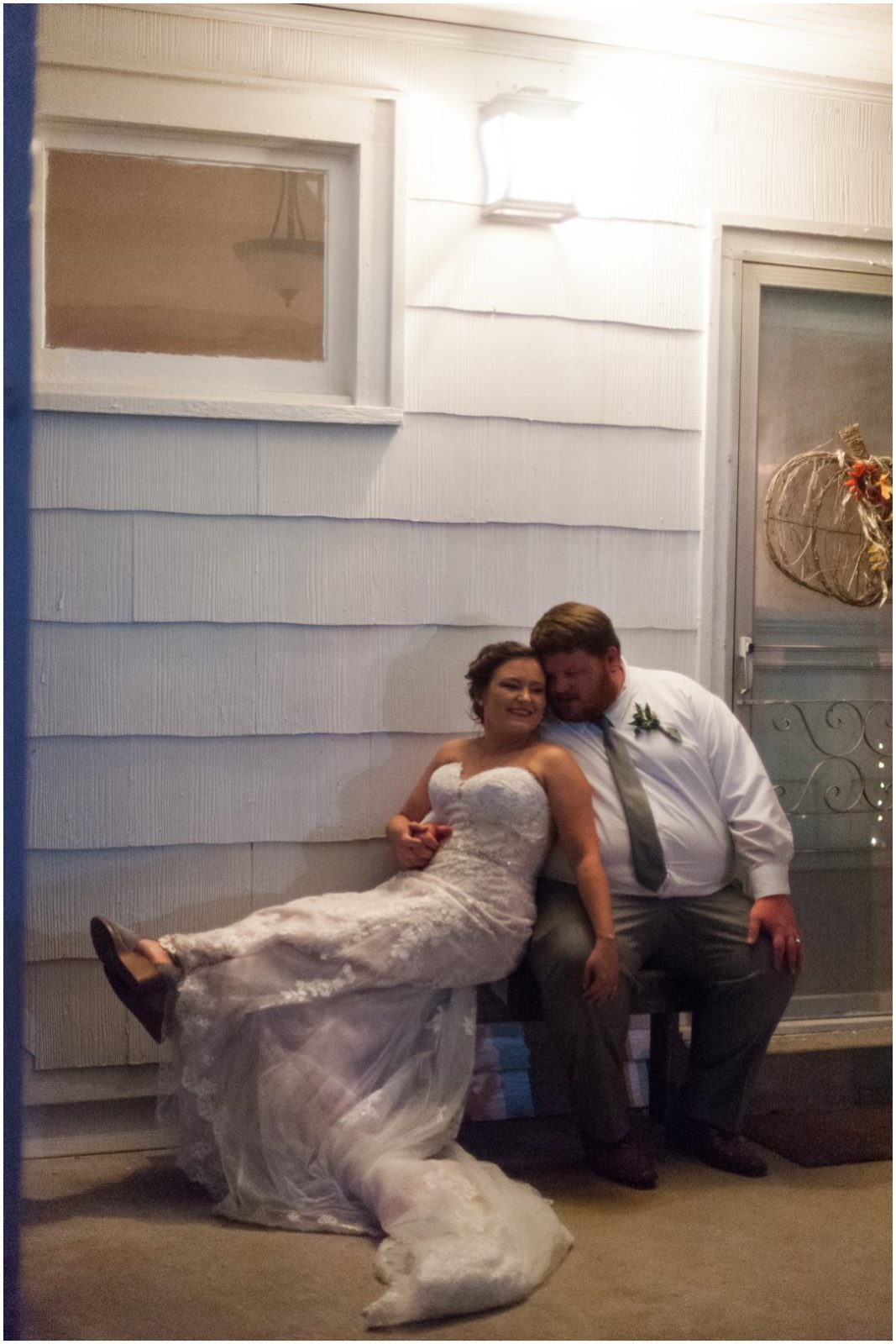 bride and groom on porch under light