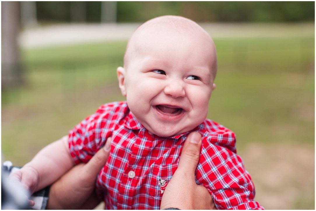 baby in red plaid laughing