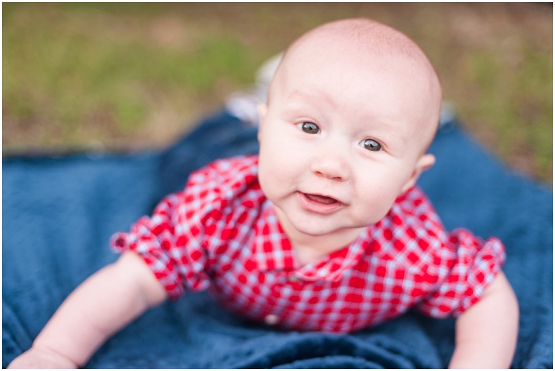 baby on blue blanket in red shirt