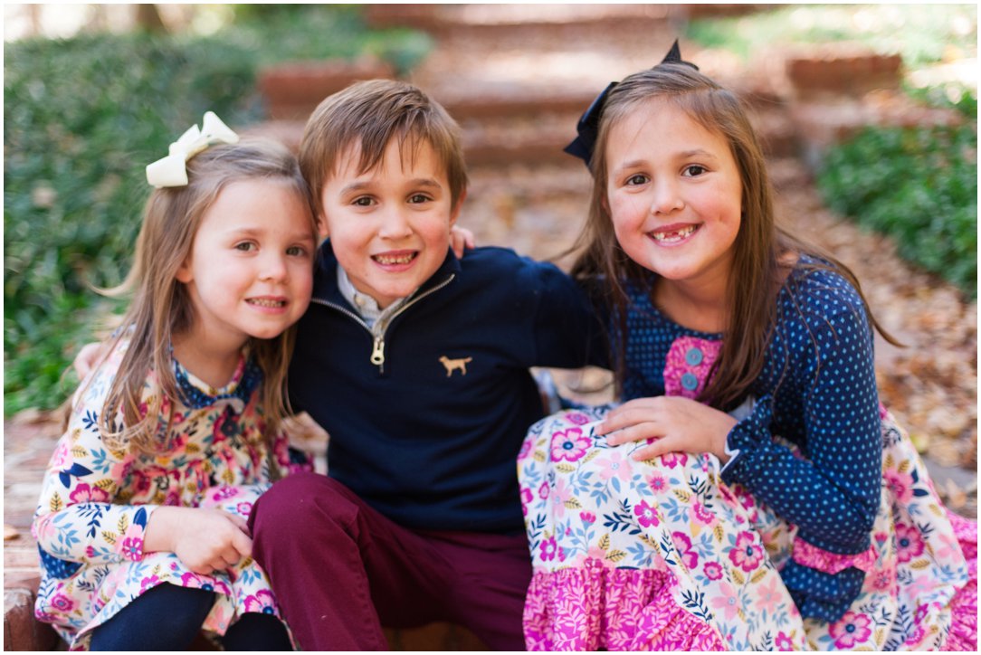 three siblings sitting on steps