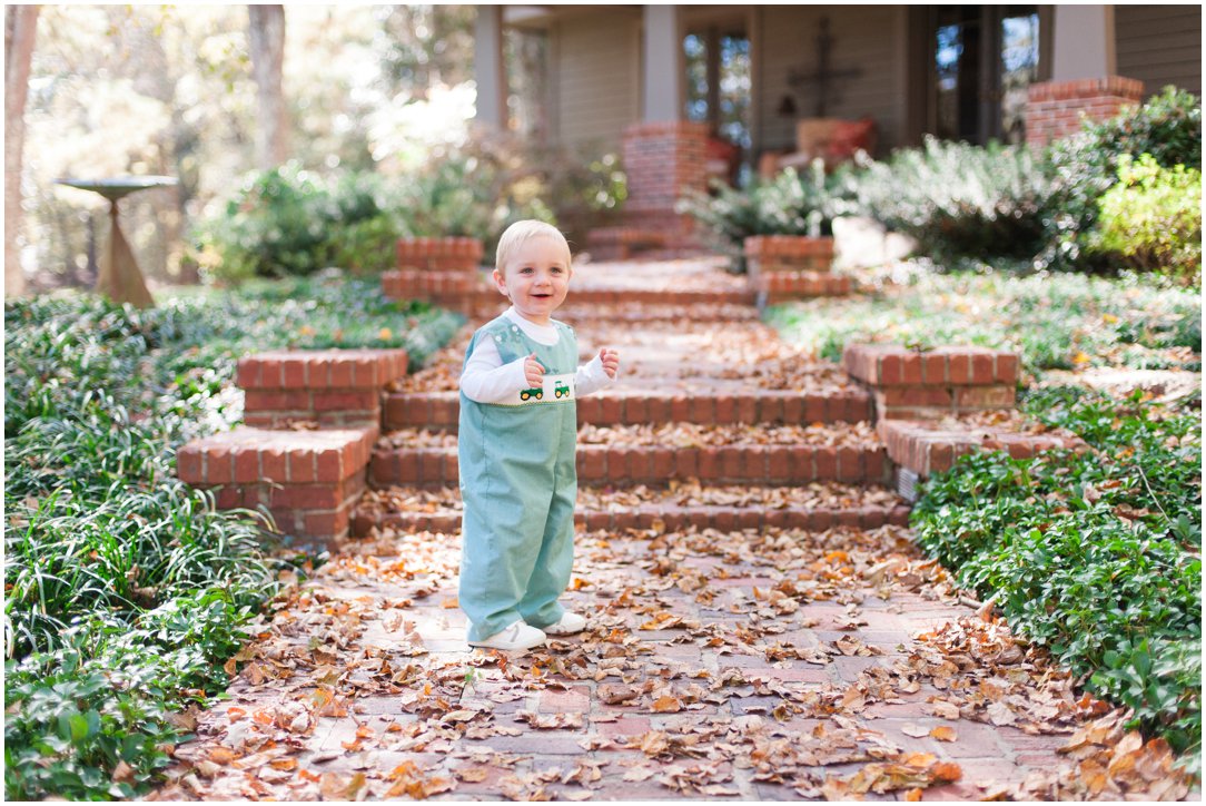 little boy in green outfit on steps