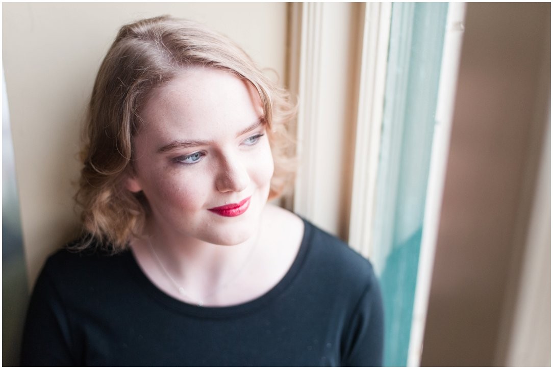 high school senior sitting by window