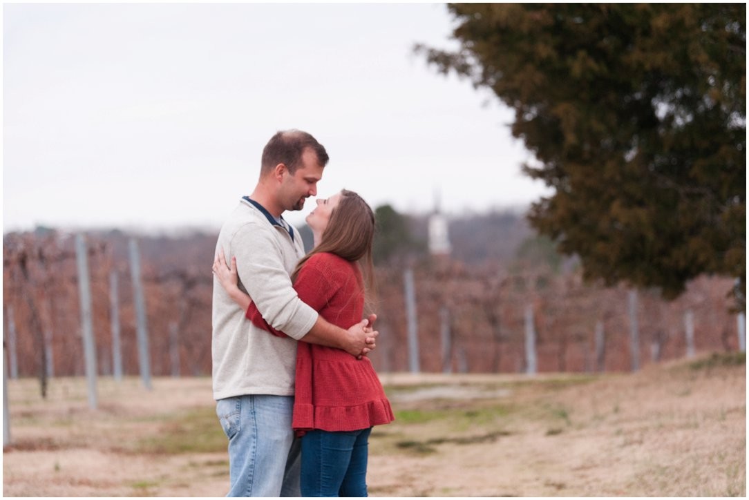 couple in field with church steeple