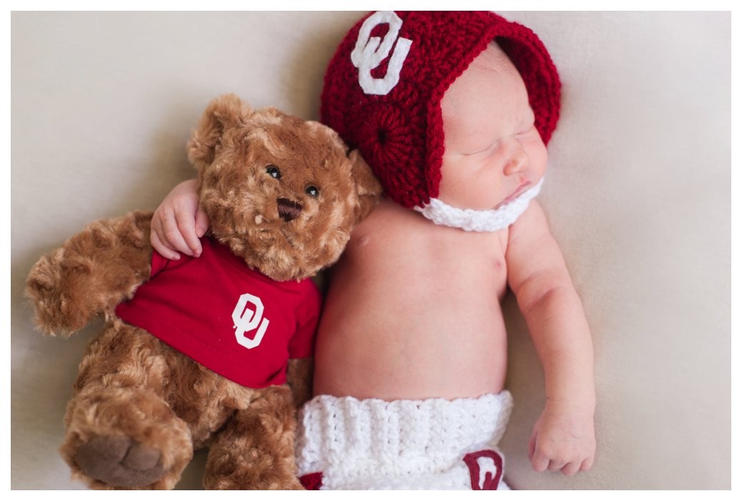 newborn with helmet and teddy