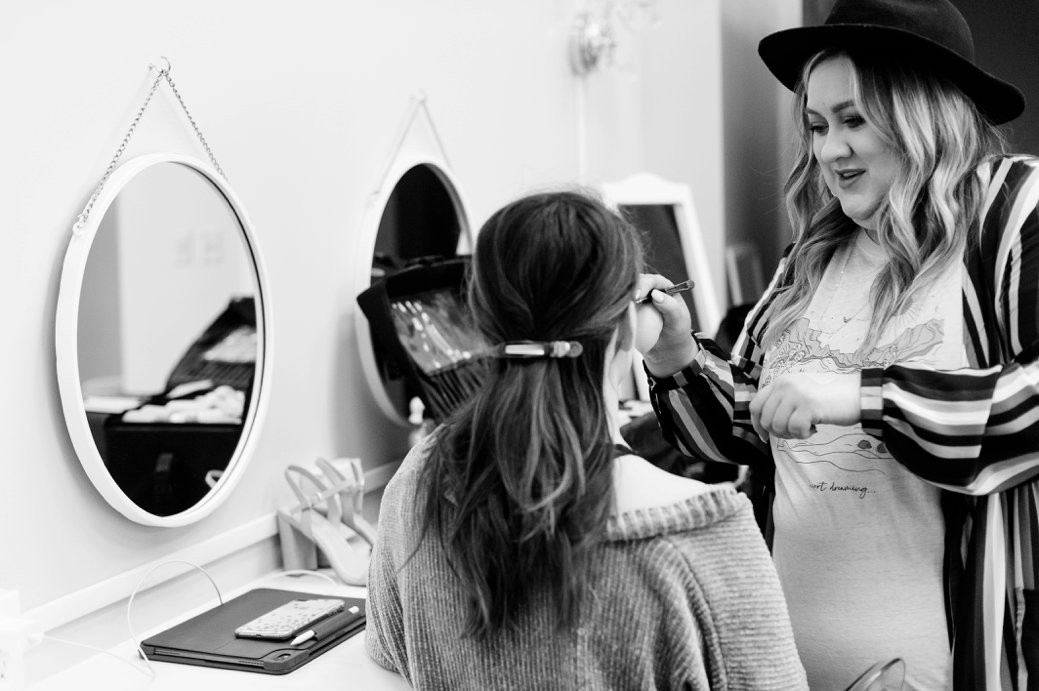 bride getting hair done in front of mirrors