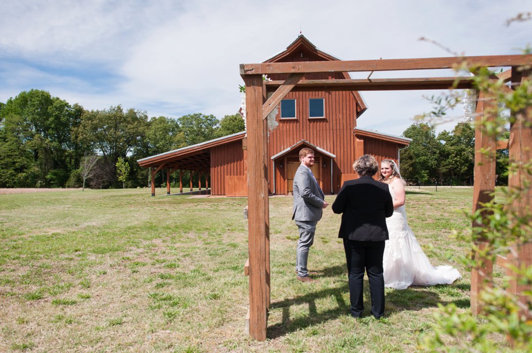 bride and groom in front of barn