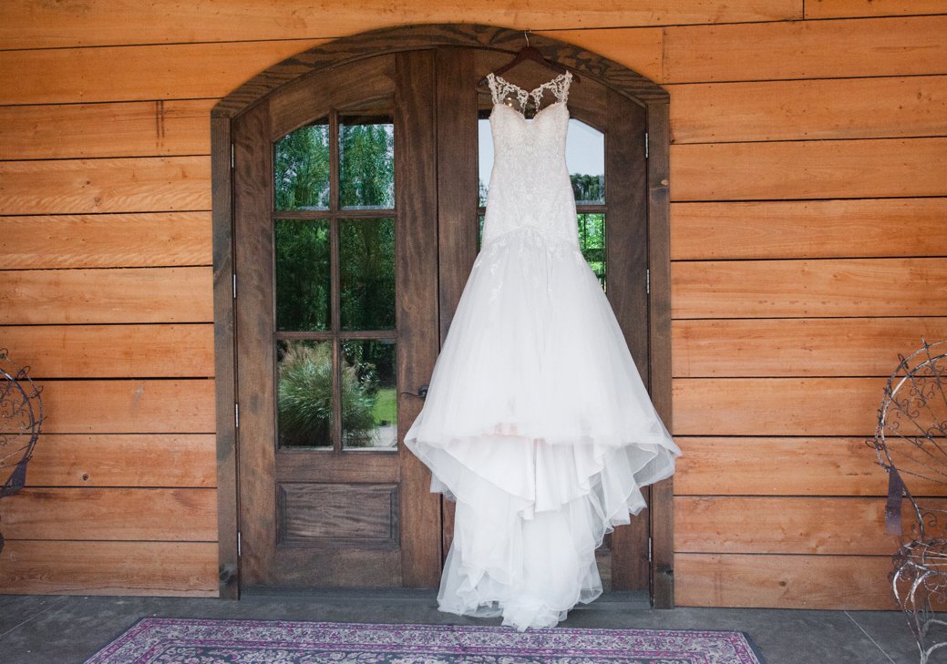 Wedding dress hanging on wood door