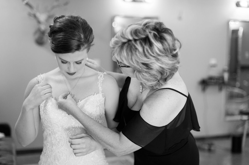 mom helping bride get dressed