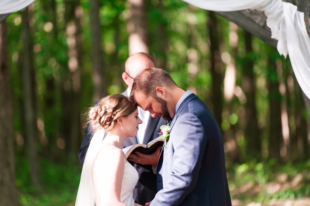 K & M Barn couple praying in ceremony