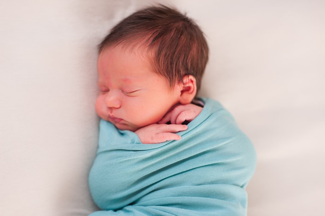 baby in teal wrap