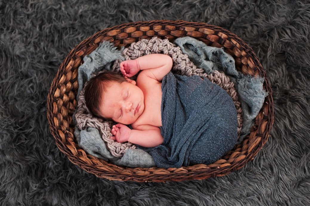 baby in blue wrap in basket