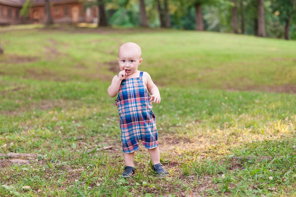 little boy standing on grass