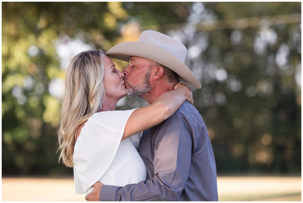 engaged couple kissing cowboy hat