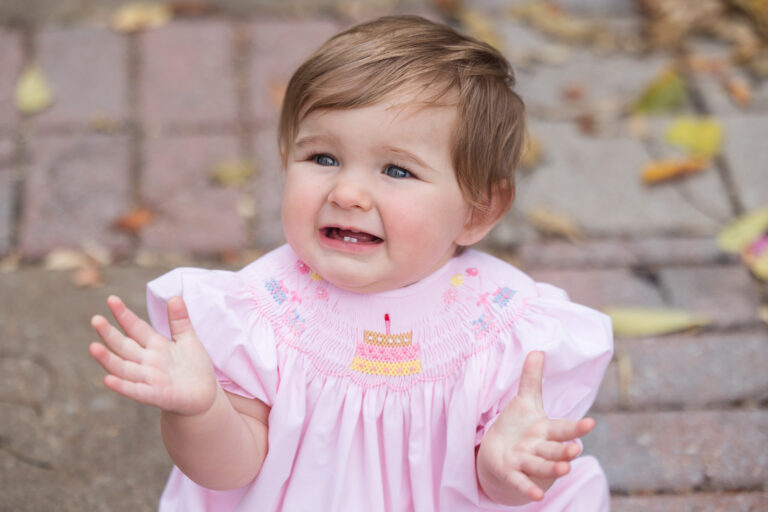 Maggie smiles and claps at her one year session