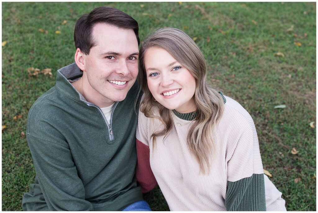 Engagement picture sitting in grass